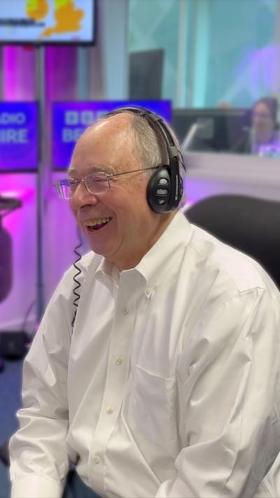 Reading owner Rob Couhig, wearing a white shirt and black headphones.