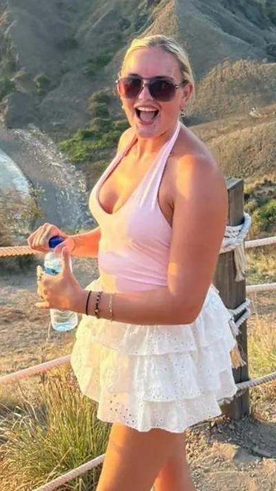 Regan Sparks stands on a hillside in a summer top and skirt