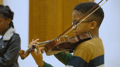 A young boy playing the violin 