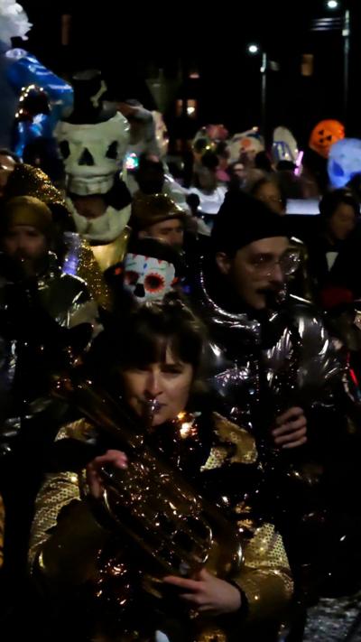 Group of people playing brass instruments, surrounded by halloween theme lanterns.
