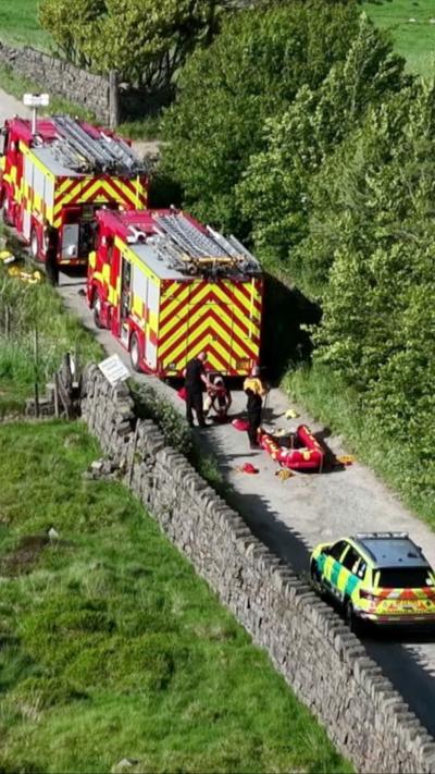 A line of emergency vehicles on a country lane