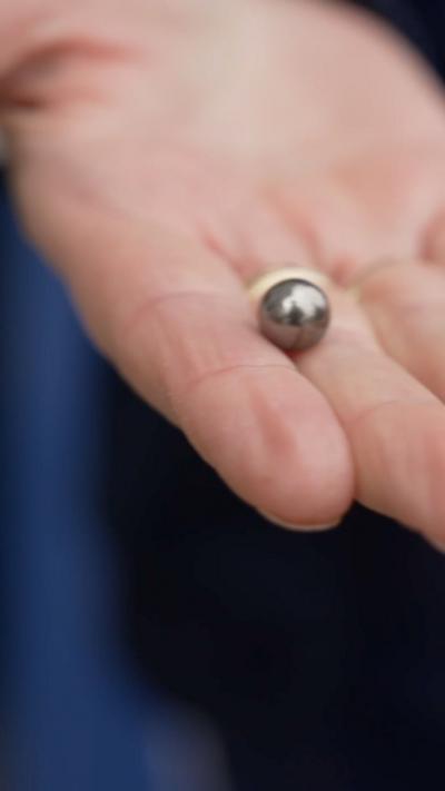 A pellet shot by a catapult in a person's hand.