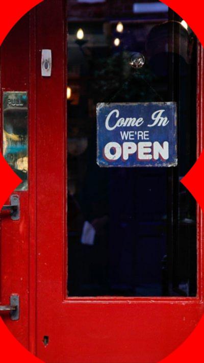 A pub door with a 'Come in we're open' sign