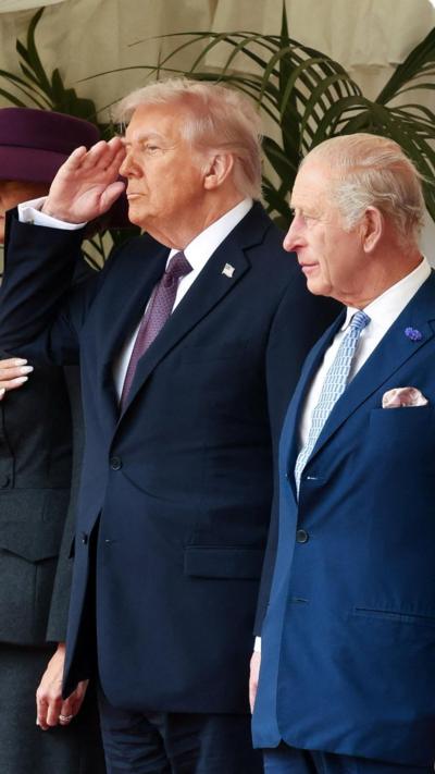 President Trump saluting next to King Charles