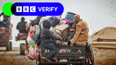 A Palestinian family riding aboard a box with their belongings, as they attempt to move South following an Israeli ground invasion