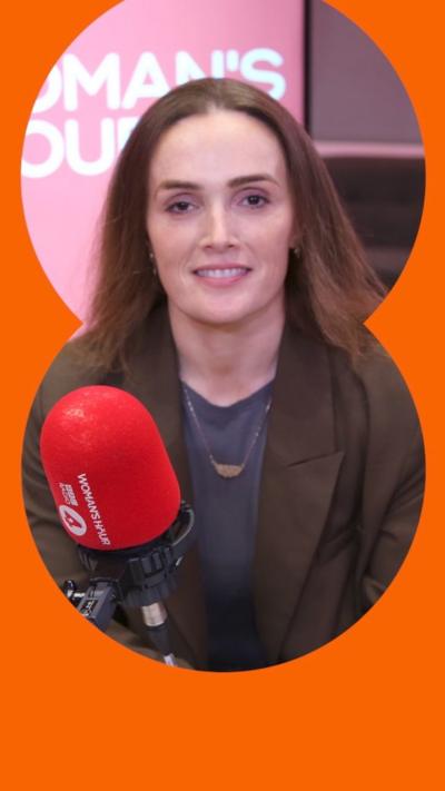 Doran smiling at the Woman's Hour studio, with a red microphone in front of her