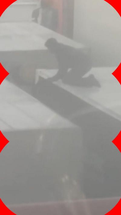 Man on top of lorry with other lorries surrounding it in foggy conditions.