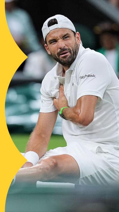 Gregor Dimitrov holds his chest and grimaces while sitting on the grass on Wimbledon's Centre Court