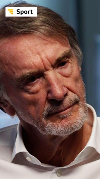 Sir Jim Ratcliffe, wearing a white shirt, sat in a room with white walls and a window