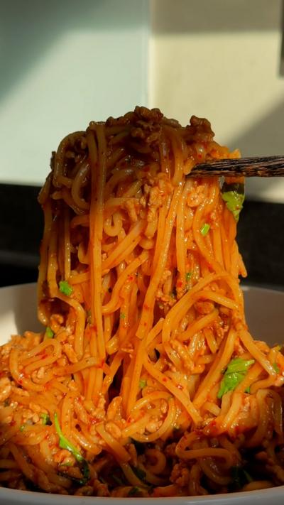 Chopsticks hold up noodles from a bowl