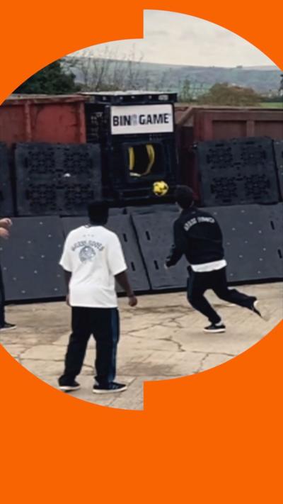 The back of two men, one in black one in white, playing bin game.