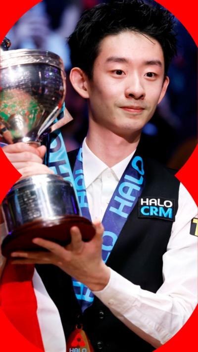 Wu Yize has short dark hair and is holding up the World Snooker Championship winning trophy