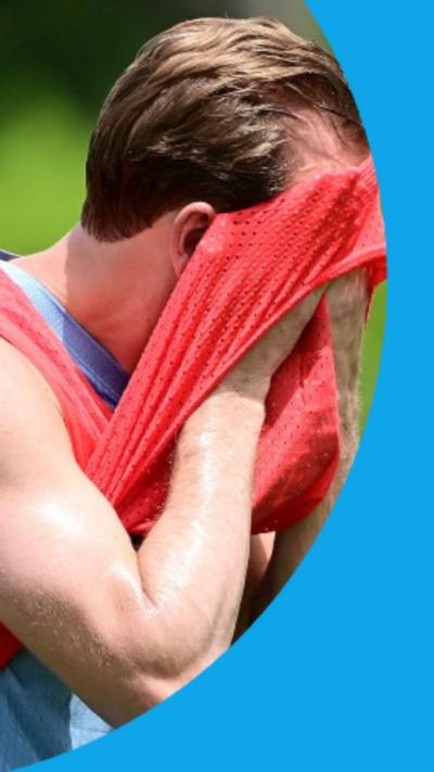 Harry Kane wiping sweat from his face with a training bib