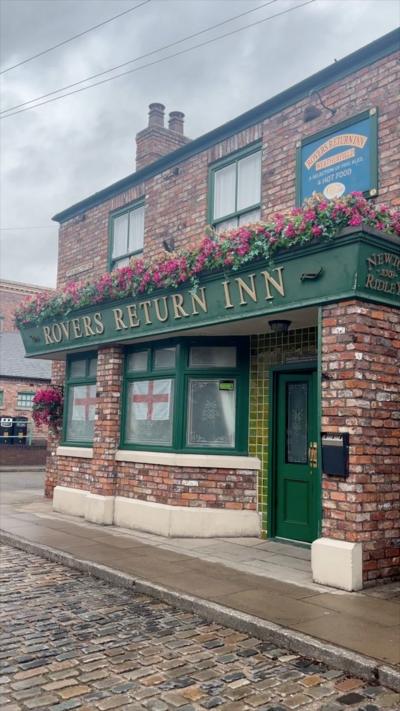 Rovers Return Inn pub from Coronation Street. It it a full brick building with a green sign.