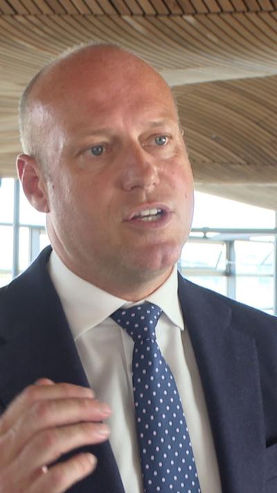 Dan Thomas, the leader of Reform UK Wales, who has a bald head and blue eyes