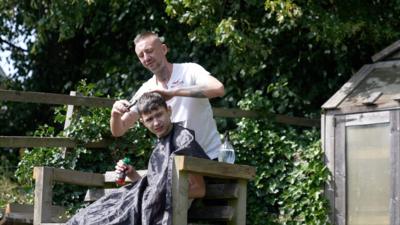 Jonathan Paton cutting an autistic client's hair outside