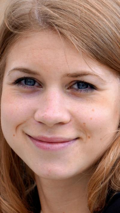 A young woman with shoulder-length brown hair smiles for the camera.