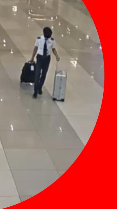 Pilot walking through airport with two suitcases