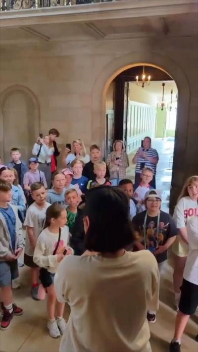 Singer Jessie J watching a crowd of school kids sing her song Flashlight back to her
