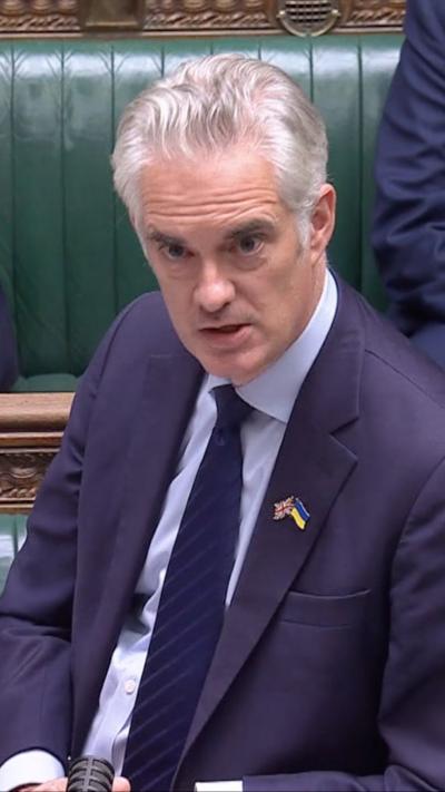 Shadow defence secretary James Cartlidge speaking in the House of Commons - he has white hair, and a UK/Ukraine pin on the lapel of his blue jacket 