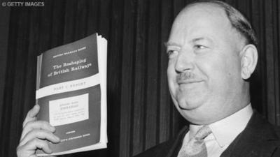 Dr Richard Beeching, later Lord Beeching, holds up his report on "The Reshaping of the Railways".