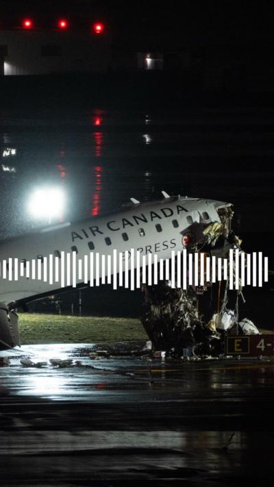 A crashed passenger is seen with a damaged nose section and sitting at an angle with the nose pointing into the sky.