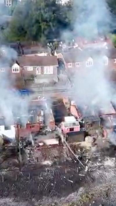 Aerial footage of smoke and an area charred by fire