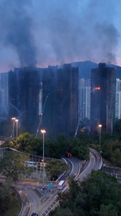 Apartment blocks seen smoking with streams of water directed at the collection on buildings.