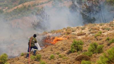 A firefighter responds to a wildfire