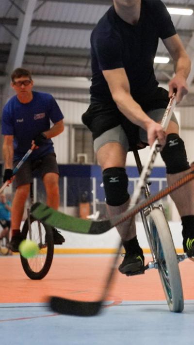 People on unicycles playing hockey