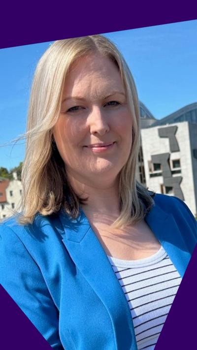 Lynsey Bewes standing in front of the Scottish Parliament