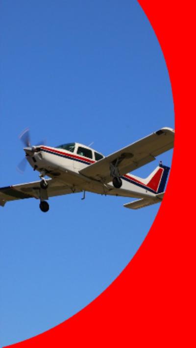 A small white aircraft with a red stripe down the middle against a blue sky
