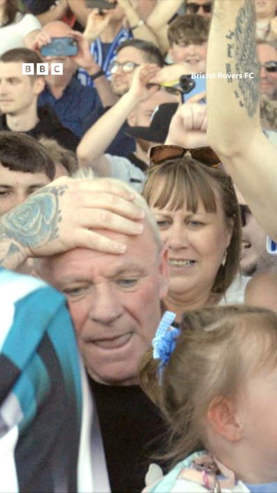 Man being held in crowd