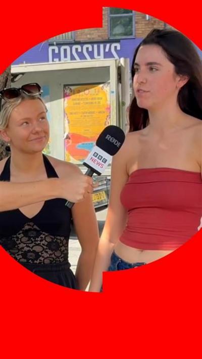 Two women speaking into a microphone