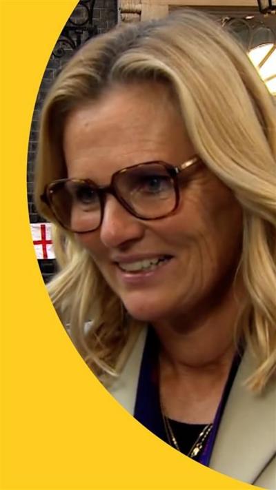 Sarina Wiegman in a beige blazer. She is blonde hair and is wearing glasses.