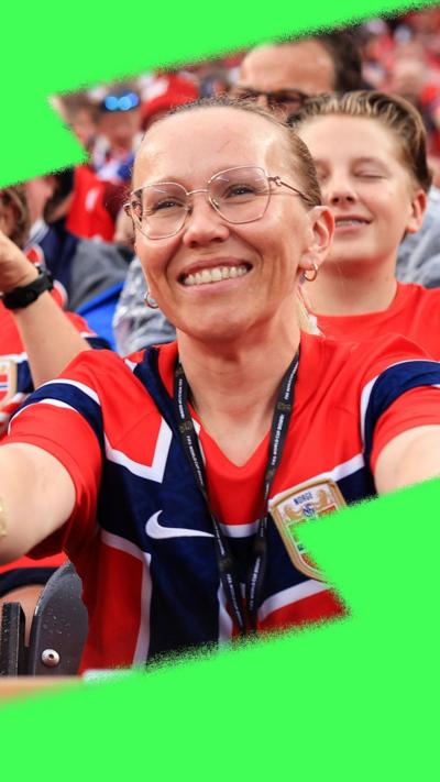 Norway fans in red football shirts doing a rowing gesture with the crowd.