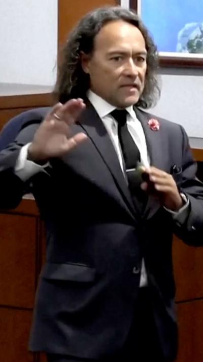 Defence attorney wearing a suit giving an opening statement.