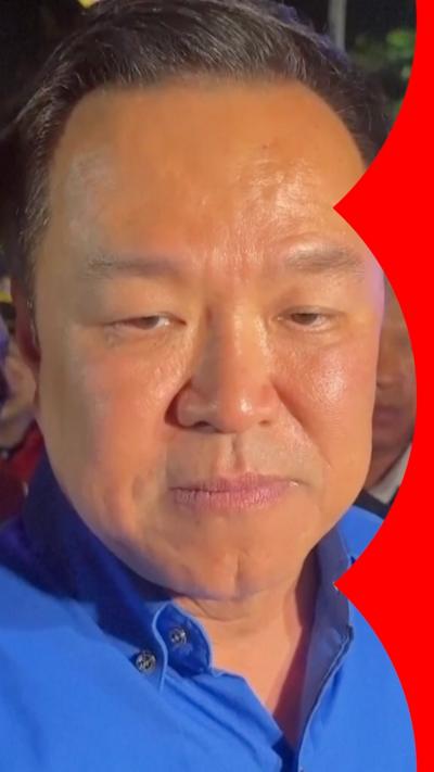 A man in a blue shirt looks at the camera