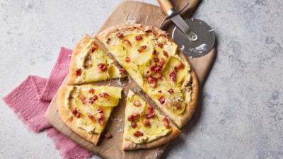A top-down image shoing a pizza cut into slices on a table.