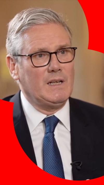 Sir Keir Starmer in a black suit with a navy blue tie. He is wearing glasses.