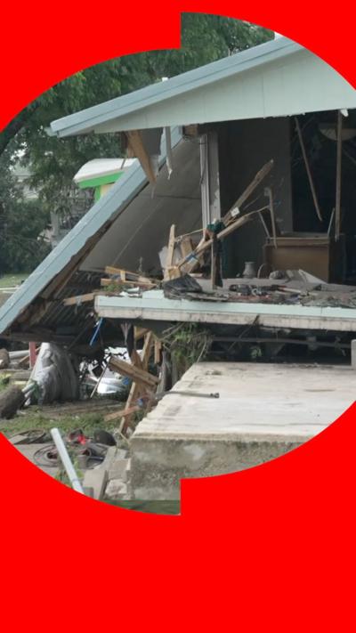 Severely damaged light blue house