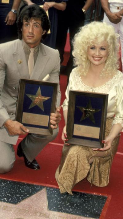 Sylvester Stallone and Dolly Parton hold plaques
