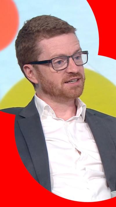 Morgan McSweeney has short ginger hair, a beard and moustache. He is wearing glasses. He is also wearing a white shirt and grey suit jacket.