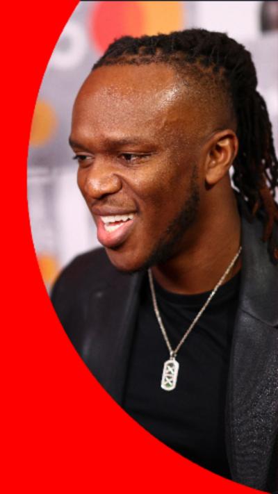 KSI is wearing a black blazer and t-shirt with a silver necklace.
