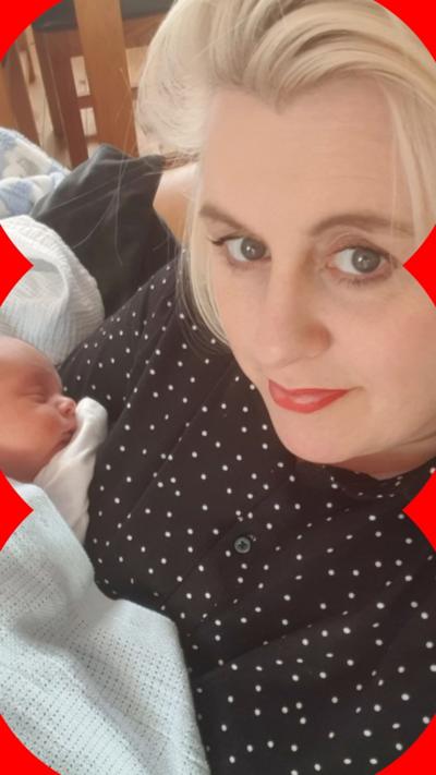 A blonde haired woman holding a new born baby