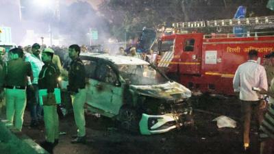 A group of men stand near a car wreckage following the explosion