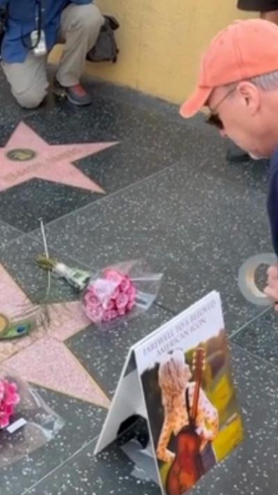 A man leaving flowers on Hollywood Star