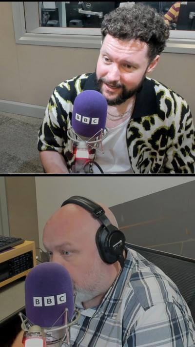Calum Scott sits in a radio studio setting behind a purple mic with the letters BBC. He is speaking with BBC Radio Humberside's Richard Stead.