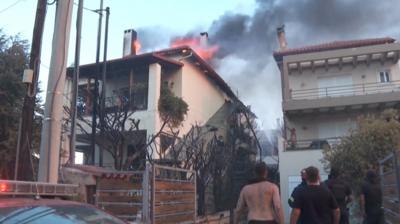 People look up at a burning building