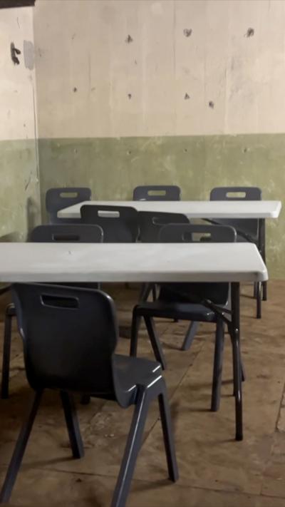 Grey and black tables and chairs set up in an underground bunker